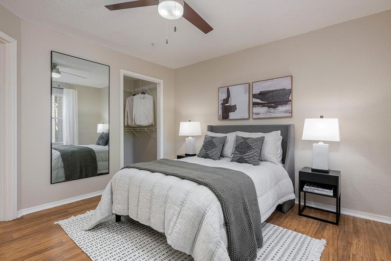 Bedroom | Spacious bedrooms featuring wood-style flooring, walk-in closets, and a multi-speed ceiling fan.