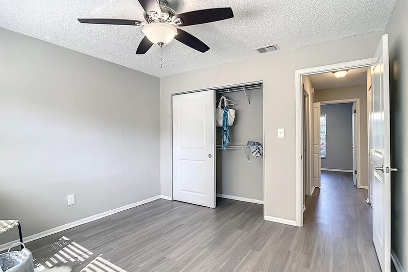 Bedroom | Bedrooms feature wood-style flooring, spacious closets, and a multi-speed ceiling fan.