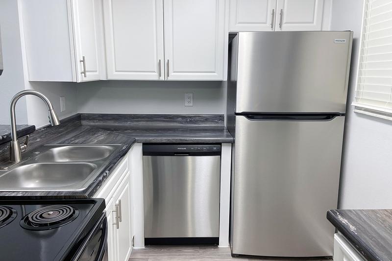 Kitchen | Newly renovated kitchens featuring black fusion countertops and ample cabinetry.