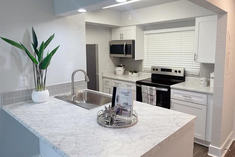 Kitchen | Our renovation package features kitchens with marble-style countertops, wood-style flooring, and stainless-steel appliances. 