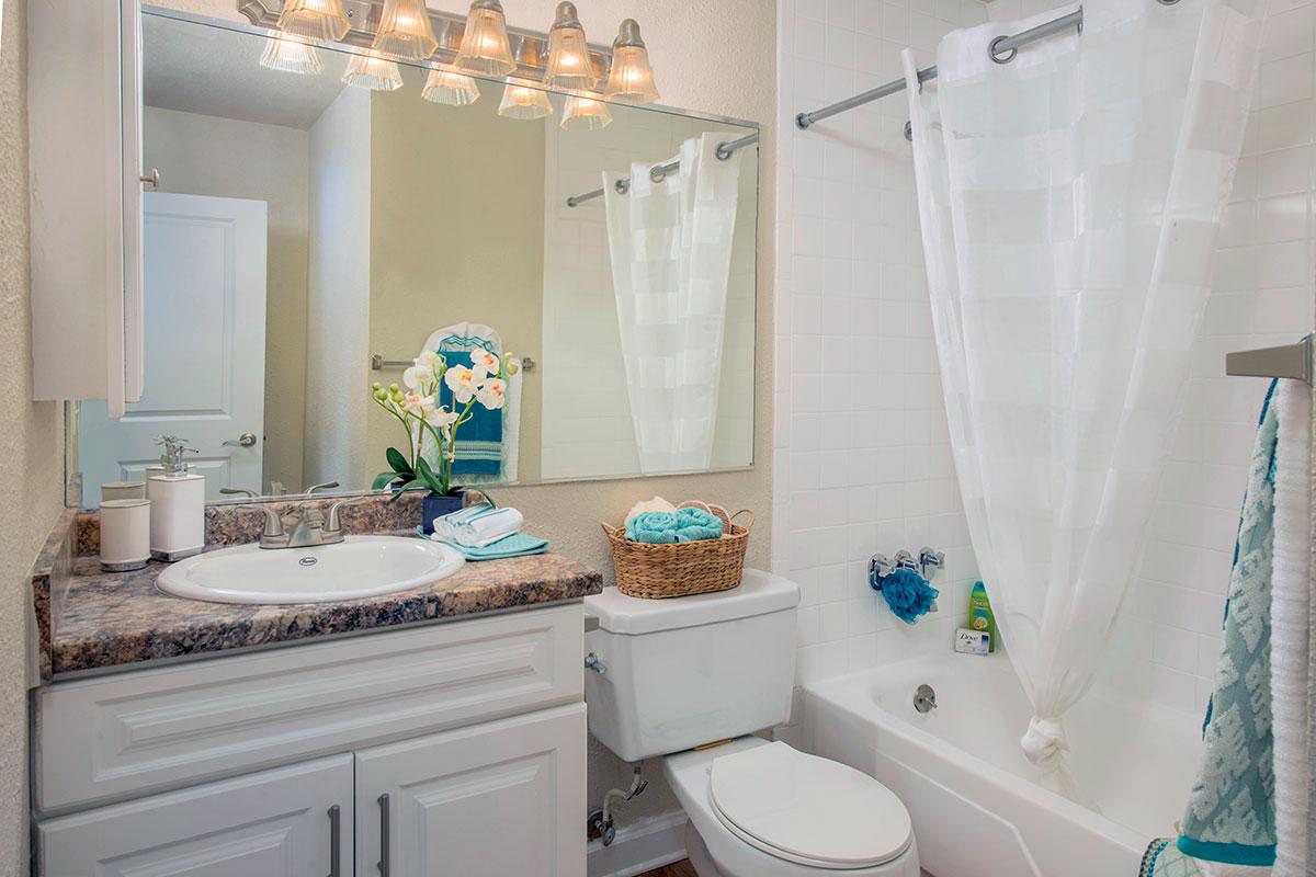 Newly renovated bathrooms with new countertops and cabinetry and large mirrors.