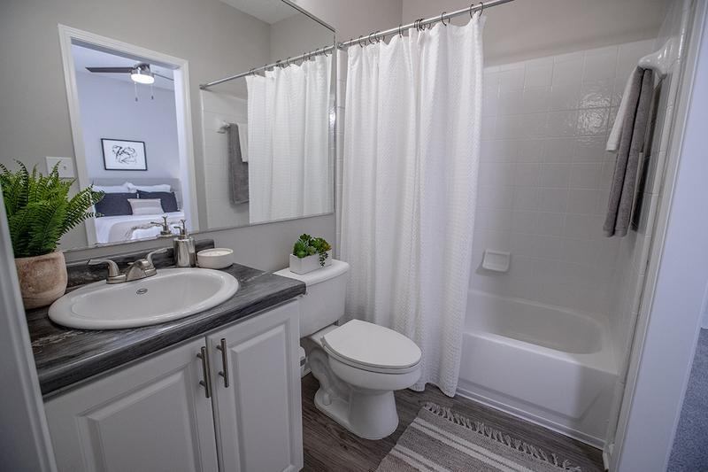 Bathroom | Newly remodeled bathrooms with brushed nickel fixtures, vast mirrors, and modern black fusion counter tops.