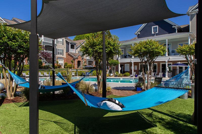 Poolside Amenities | Enjoy all our poolside amenities including an outdoor kitchen, firepit, cornhole, and hammocks.