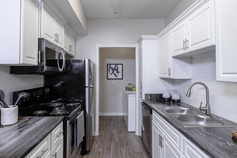 Stainless Steel Appliances | Renovated kitchens feature wood-style flooring, white cabinetry, and stainless steel appliances.
