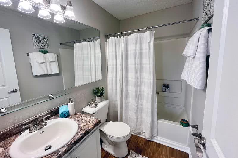 Bathroom | Bathrooms featuring wood-style flooring, granite-style countertops, and large mirrors.