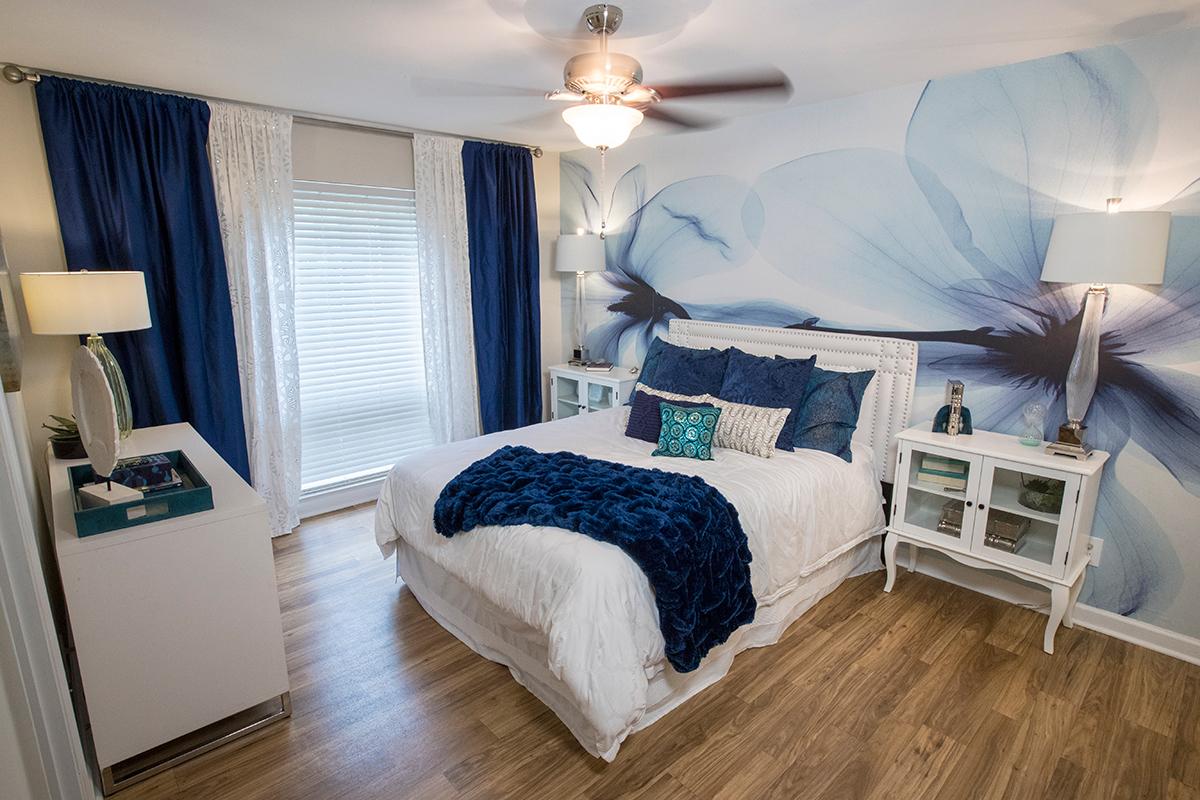 Master bedroom featuring a ceiling fan, a walk-in closet and an en-suite bathroom.