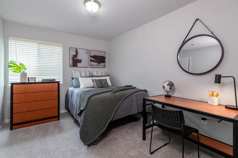 Bedroom | Bedrooms feature plush carpeting and large windows with wood-style blinds.