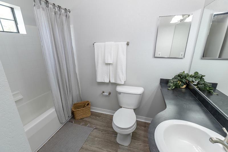 Private Bathroom | All bathrooms feature wood-style flooring and large mirrors.