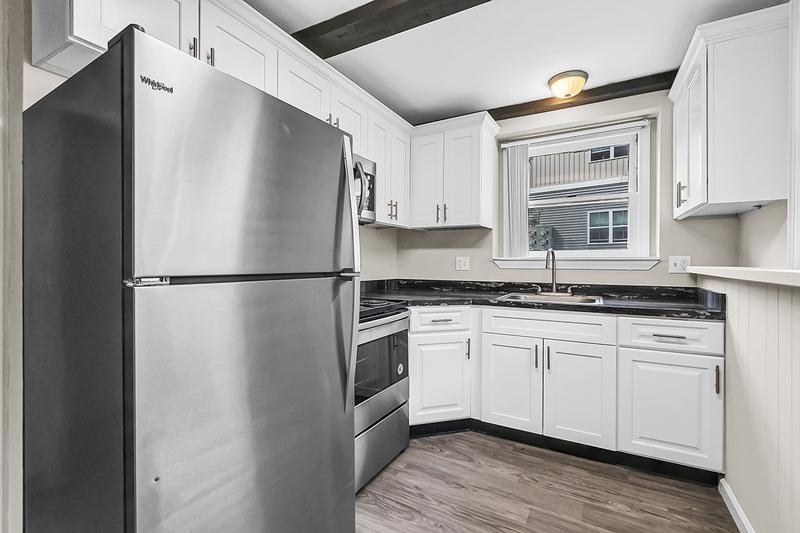 Studio Kitchen | Kitchens feature wood-style flooring, marble-style countertops, and stainless steel appliances.