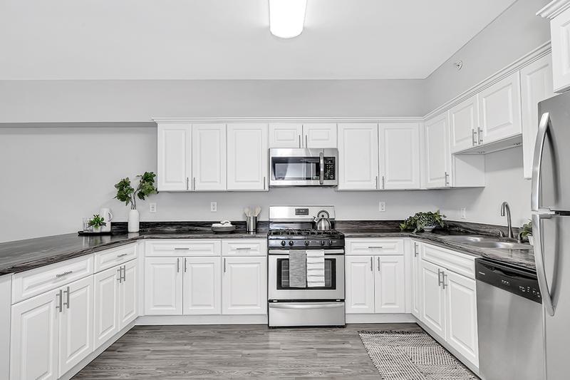 4 Bed 4 Bath Kitchen | Kitchens in our 4 bed 4 bath offer ample cabinetry, wood-style flooring, and stainless steel appliances.