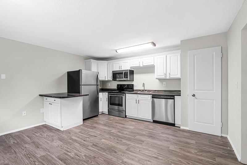 3 Bedroom Kitchen | Our 3 bedroom kitchen features wood-style flooring, marble-style countertops, and stainless steel appliances.