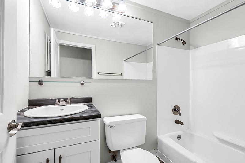 3 Bedroom Bathroom | The Alma Mater bathroom features marble-style countertops and large mirrors. 