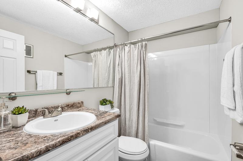 Bathroom | Updated bathrooms featuring granite-style counters and large mirrors.