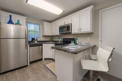 Modern Style Kitchens | Newly renovated kitchens featuring black fusion counter tops, wood-style flooring, and stainless steel appliances. We are excited to offer in-person tours while following social distancing and we encourage all visitors to wear a face covering.