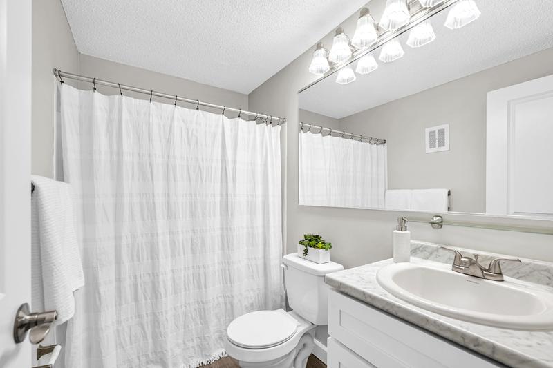 Bathroom | Newly remodeled bathrooms featuring wood-style flooring and marble-style counter tops. 