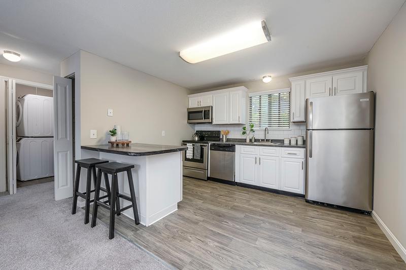 1 Bedroom Kitchen | Spacious kitchens featuring wood-style flooring, granite-style countertops, and stainless steel appliances.