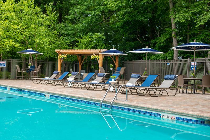 Poolside Seating | Our pool area features plenty of seating options including loungers and tables with umbrellas.