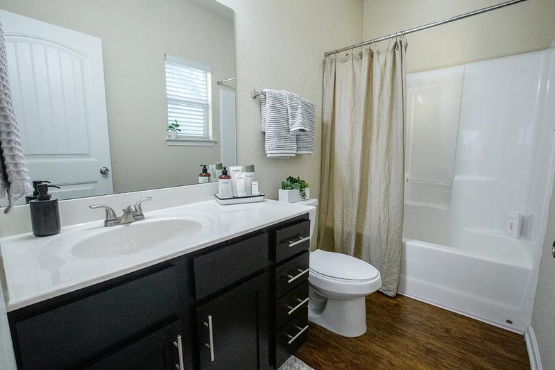 Guest Bathroom | Bathrooms featuring large mirrors, porcelain countertops and extra storage.