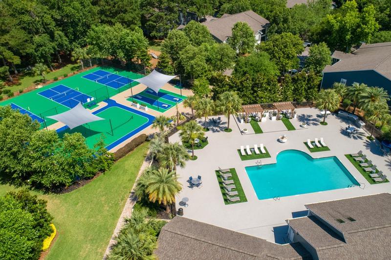 Aerial View of Outdoor Amenities | A bird's eye view of our outdoor recreational areas featuring a pool, sundeck, pickleball court, outdoor fit zone, and more!