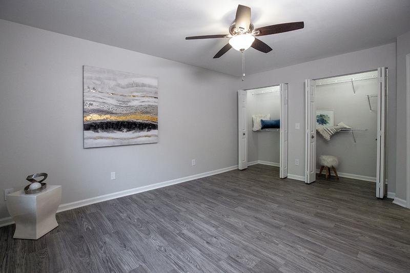 Bedroom | Spacious bedrooms featuring wood-style flooring, large closets, and a multi-speed ceiling fan.