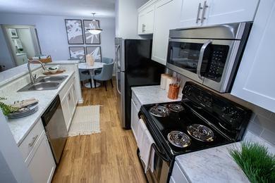 Galley Style Kitchens | Select floor plans featuring galley style kitchens featuring white marble-style countertops and stainless steel appliances.