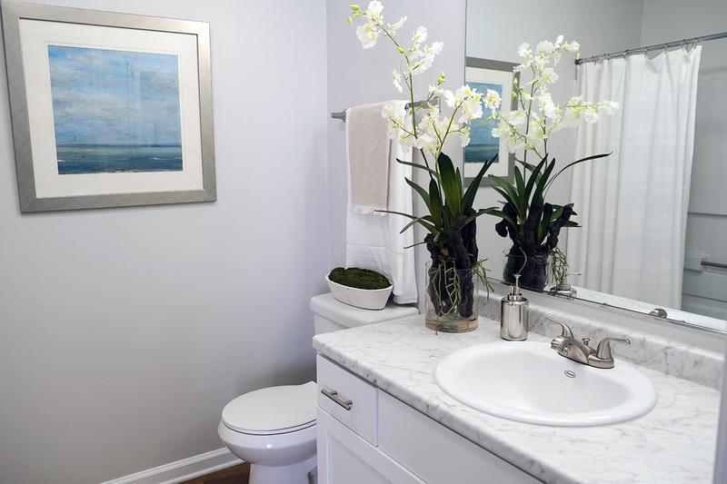 Bathroom | Bathrooms feature granite-style countertops, wood-style flooring, and large mirrors. 