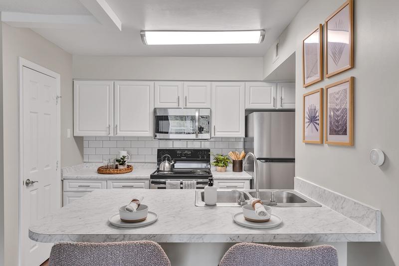 Kitchen | Newly renovated kitchens with wood-style flooring, white carrera counter tops, and stainless steel appliances.