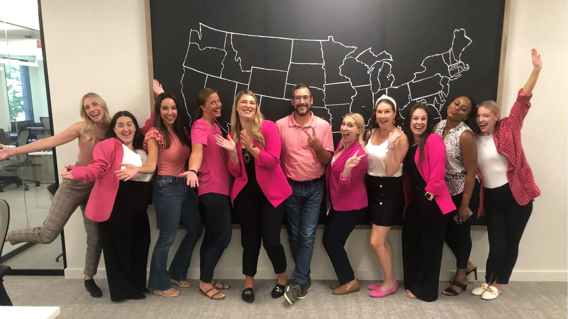 A group of employees at the home office wearing pink.