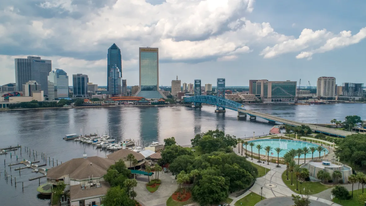 A stunning aerial view of Jacksonville's skyline, with the iconic Main Street Bridge arching over the St. Johns River. This vibrant city offers residents a perfect blend of urban amenities and natural beauty.