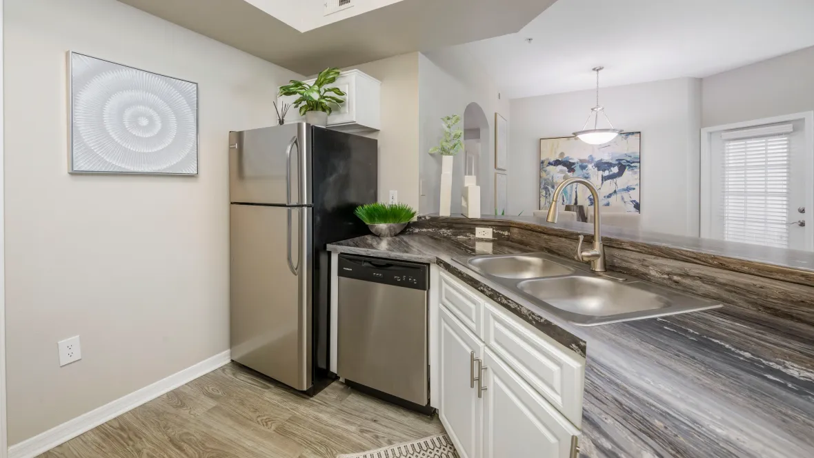 A stunning kitchen featuring stainless steel appliances, granite-like countertops, and a spacious bar top. This newly renovated kitchen offers residents the ultimate culinary experience, with all the bells and whistles.