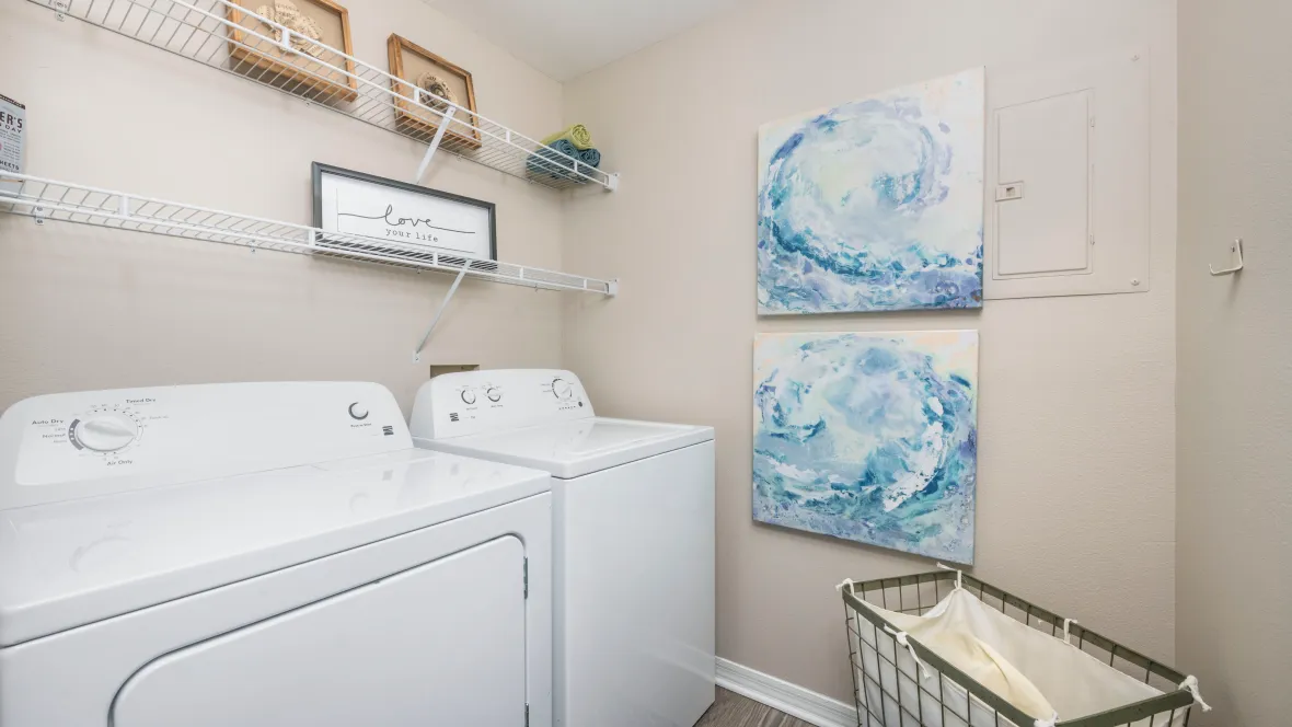 A large laundry room conveniently located off the kitchen with extra shelving above the full size appliances – perfection for our residents. 