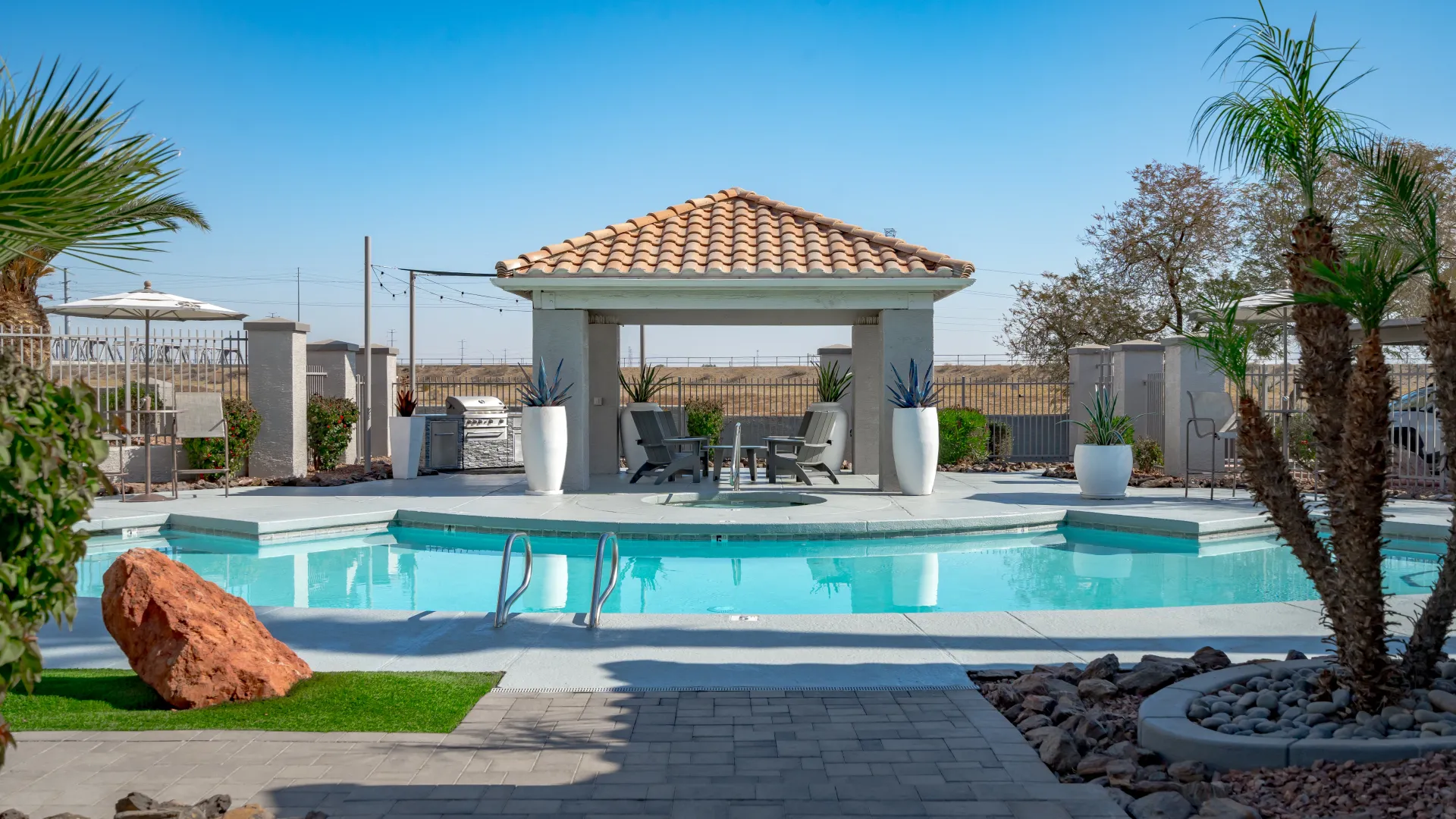 Luxurious, inviting pool with spa and various seating options to enjoy the poolside amenities.