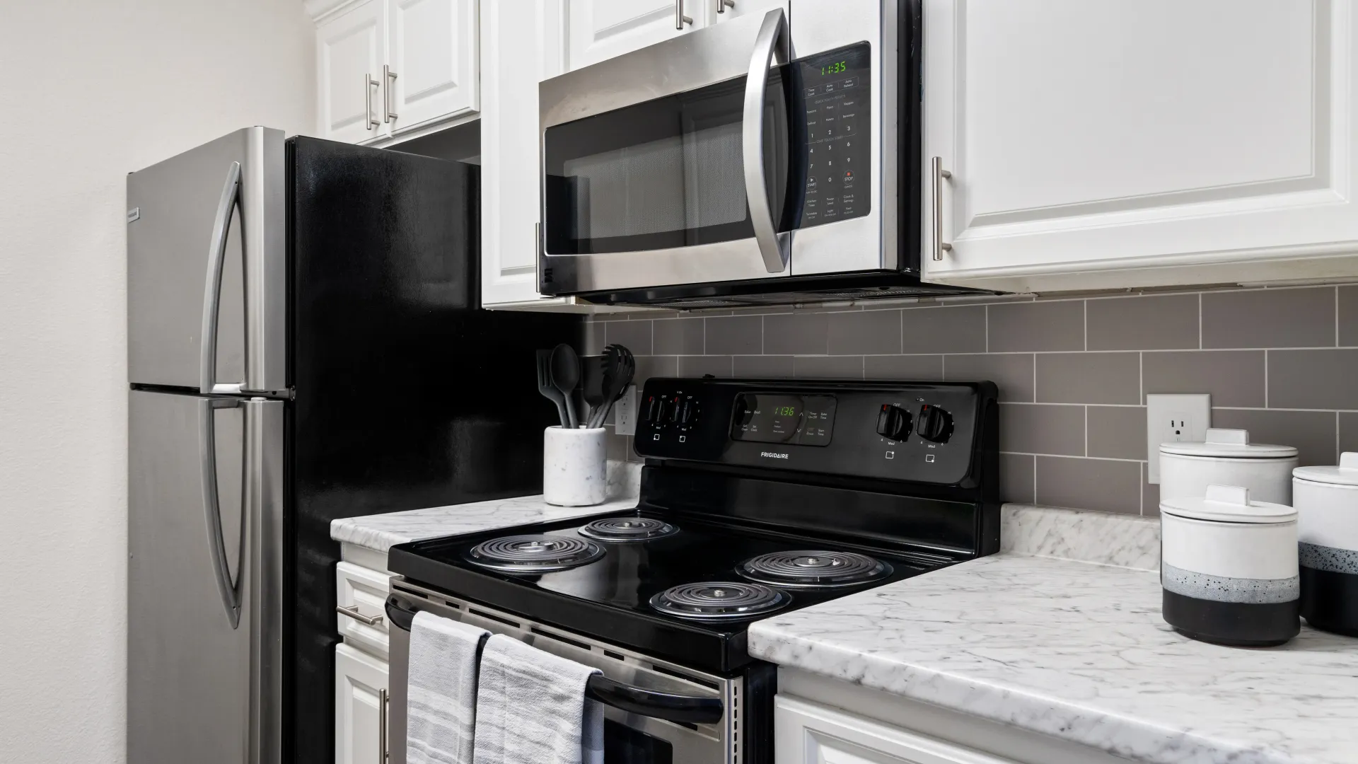 Kitchen with stainless steel appliances, white cabinetry, and a subway tile backsplash at Sedona Peaks.