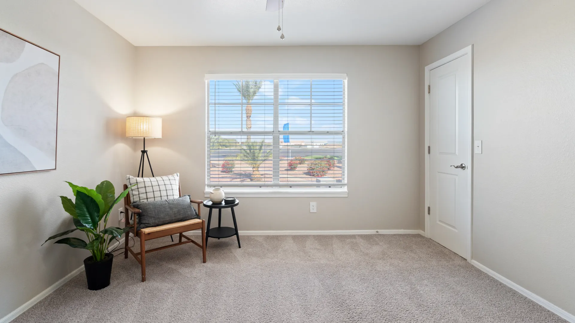 A well-lit bedroom at Sedona Peaks with a large window, cozy chair, and modern decor.