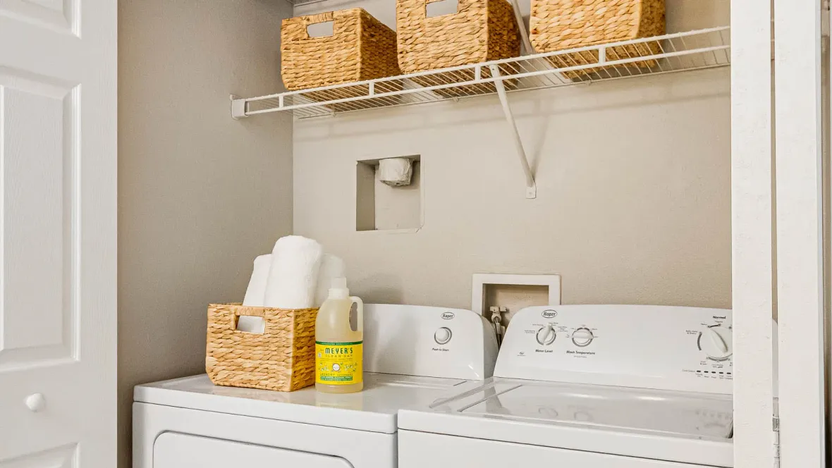 In-unit washer and dryer set with additional shelving overhead for laundry day ease. 