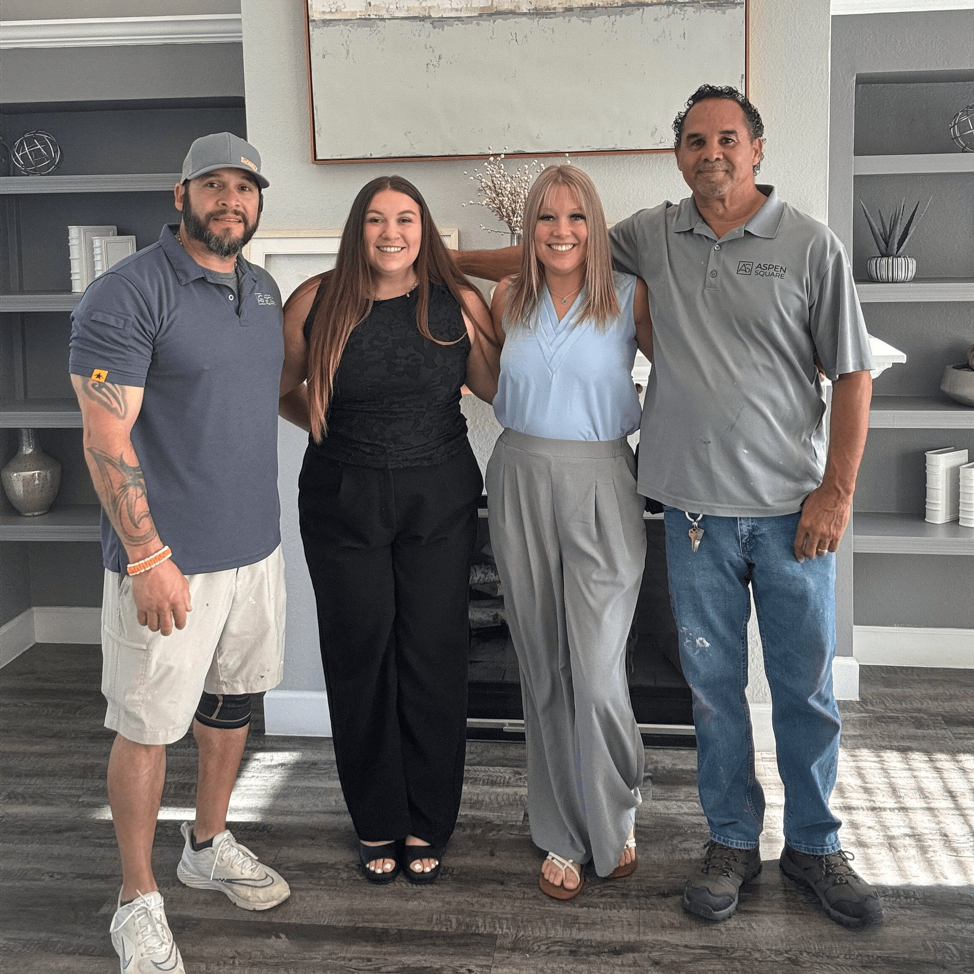 Four Sedona Peaks team members standing together in a modern clubhouse, representing the community’s friendly and professional team.