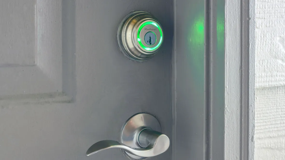 Kwikset deadbolt lighted green at home entrance door. 