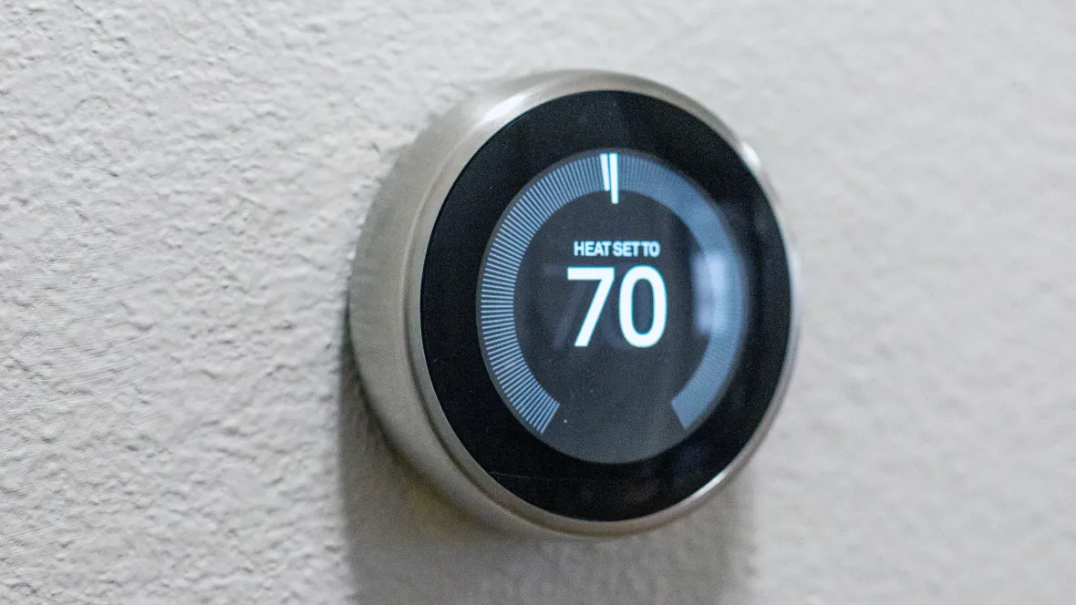 Zoomed in look at a Nest smart thermostat for convenient temperature control.