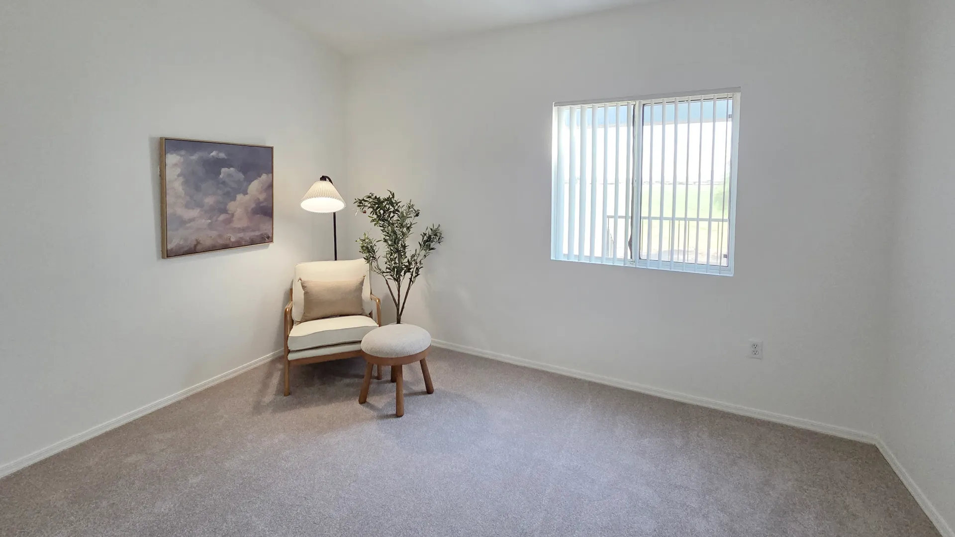 Bright bedroom at Riverwood Apartments with plush carpeting, large window, and spacious layout.