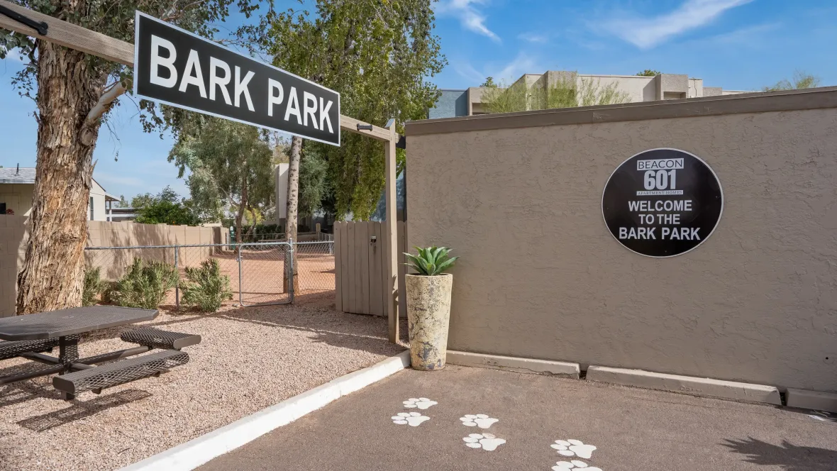 A welcoming entry to a pristinely maintained community dog park with playful pays leading the way. 