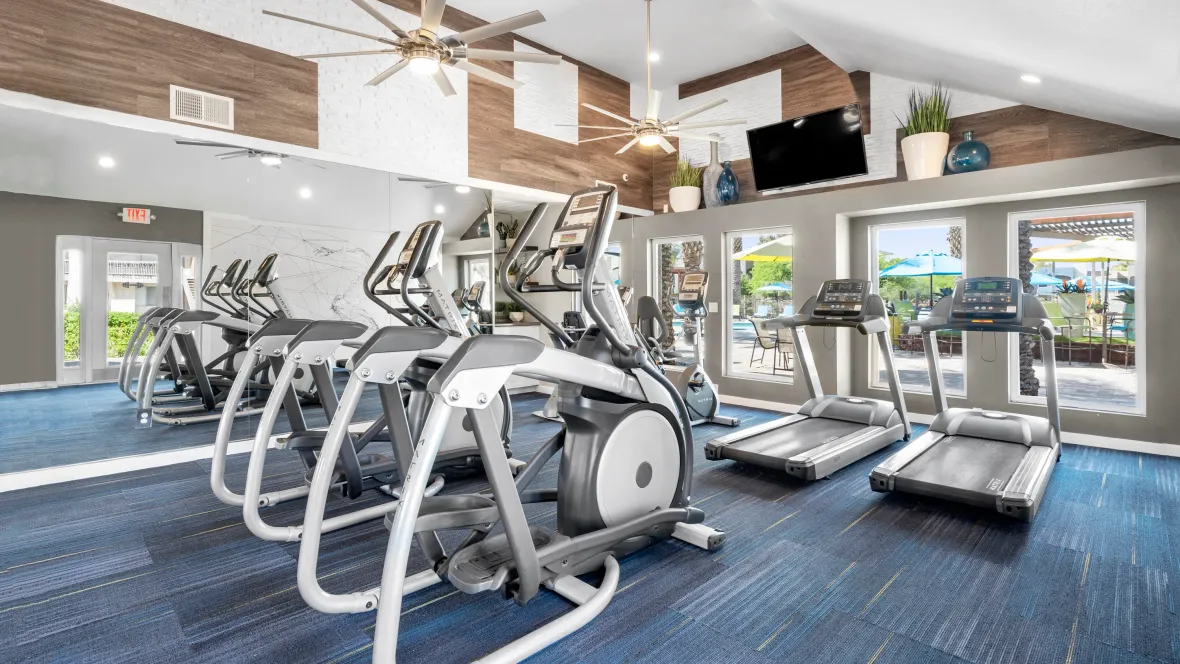 An extraordinary fitness zone featuring a wide array of dynamic cardio and weight training gear, exercise mirrors, and breathtaking panoramic pool-deck views.