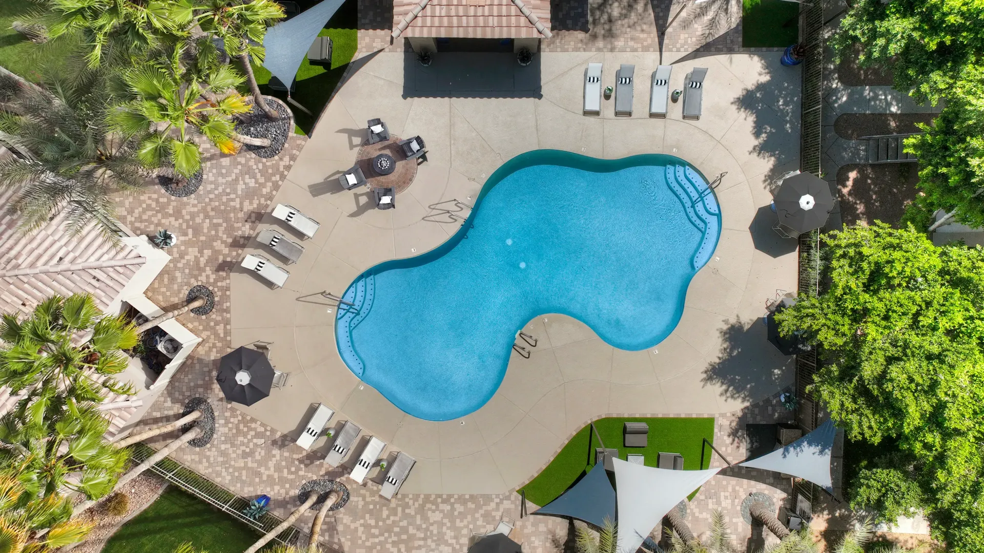An aerial view of the sun deck overlooking the picturesque pool, creating a regal poolside paradise.