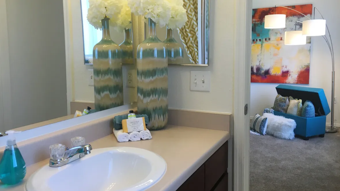 Stylish master bathroom with ample vanity space and a chic, oversized mirror and a mirrored medicine cabinet. 