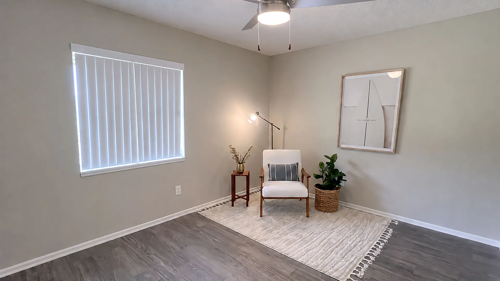 Rancho Del Sol living room with wood-style flooring, ceiling fan, large window with vertical blinds, and neutral finishes.