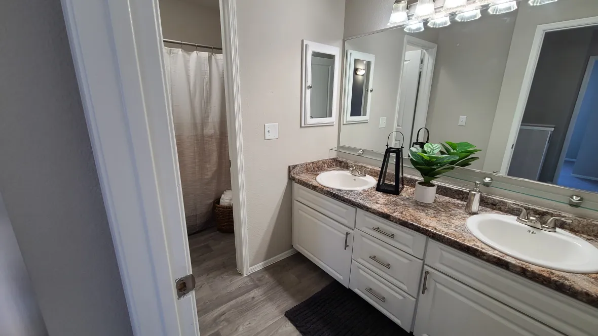 Huge bathroom with granite-style countertops, wall-to-wall mirror, and exceptional cabinet space and drawers for all your personal hygiene items.