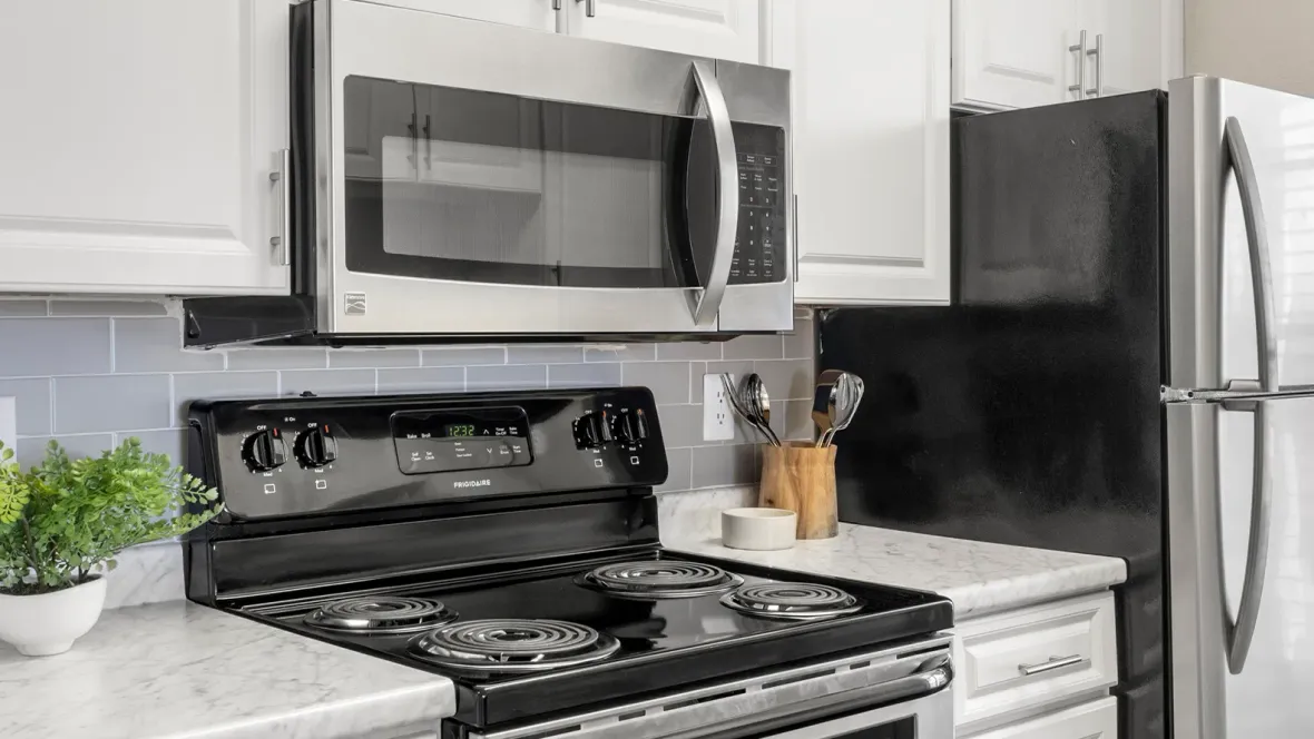 Sleek stainless-steel appliances and chic grey backsplash offer a gleaming culinary space.