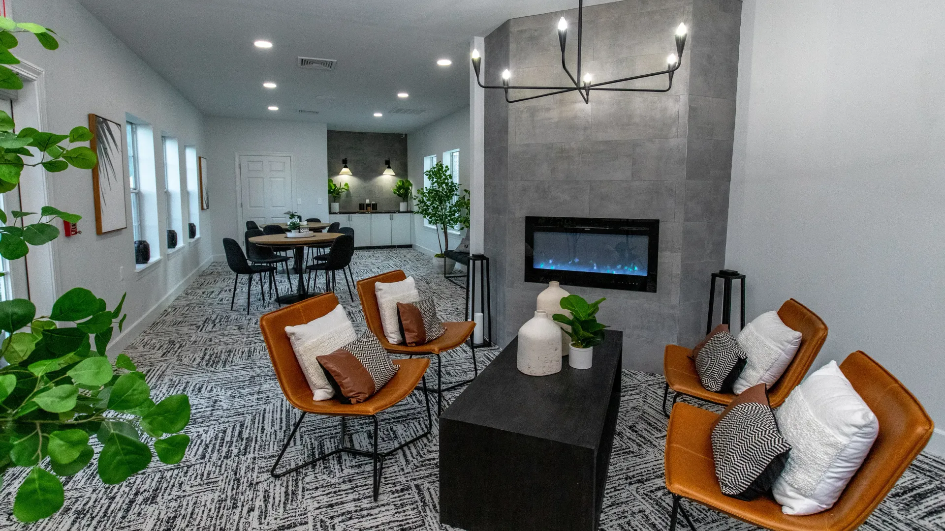 Comfortable leather chairs, centered around an inviting electric fireplace in the clubhouse, creating a warm and sociable atmosphere.