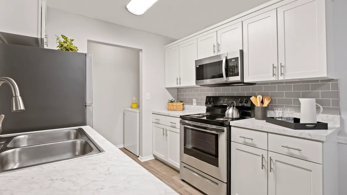 A stylish, well-equipped kitchen with a convenient, adjacent laundry area.
