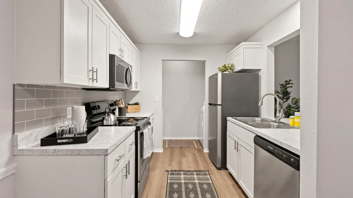 A modern galley-style kitchen with laundry room access.