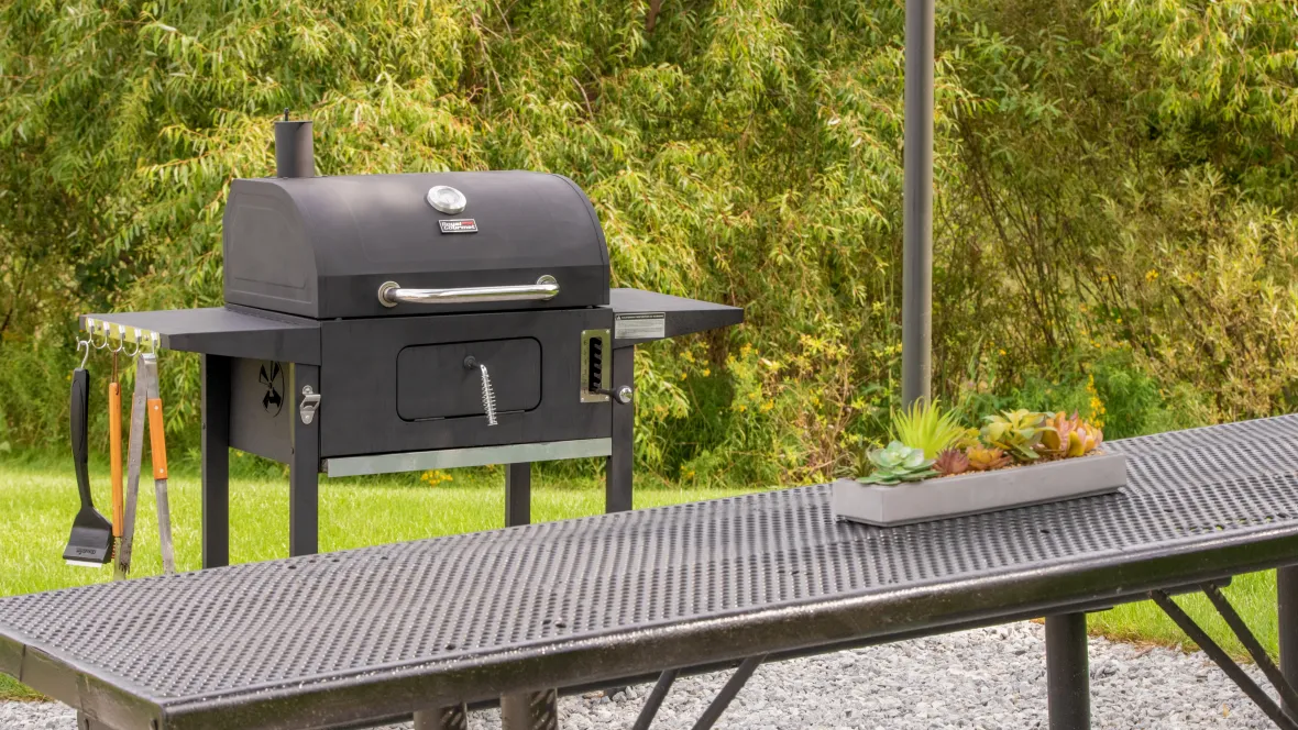 Grilling stations with grills and picnic tables.